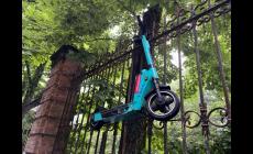 Parcheggio fantasioso: il monopattino appeso alla cancellata del Parco Ducale