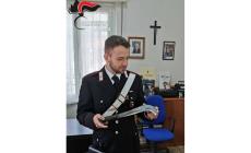 Litiga con i vicini, perde la testa, li minaccia con una roncola: poi distrugge i vetri delle loro auto e li prende a calci e pugni