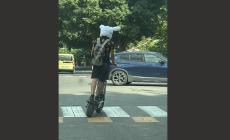 In monopattino  senza casco ma  con un cappello con orecchie di coniglio

