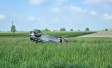 Auto vola fuori strada e si ribalta nel campo