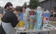 A Bucha adolescenti e artisti dipingono resti di munizioni e auto bruciate
