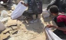 Gaza, i palestinesi raccolgono da terra il cibo in un centro di distribuzione