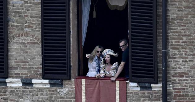 Madonna aspetta l'inizio del Palio da una finestra di Palazzo Pannocchieschi d'Elci
