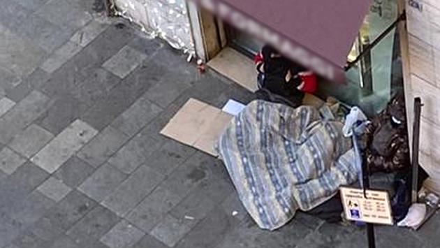 Senzatetto dorme davanti a negozio