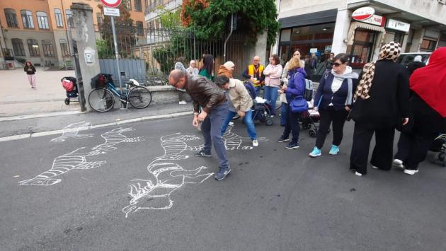 Genitori disegnano zebre sull'asfalto davanti a scuola