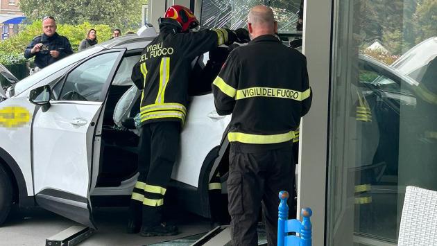 L'auto ibrida  per un guasto, ha innestato la retromarcia, ha preso velocità e si è infilata in una vetrina di un negozio