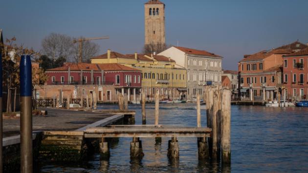 Ragazzi giocano a palla in campo veneziano, genitori in caserma