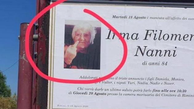 In manifesto funebre a Rimini foto di una defunta che fa il dito medio