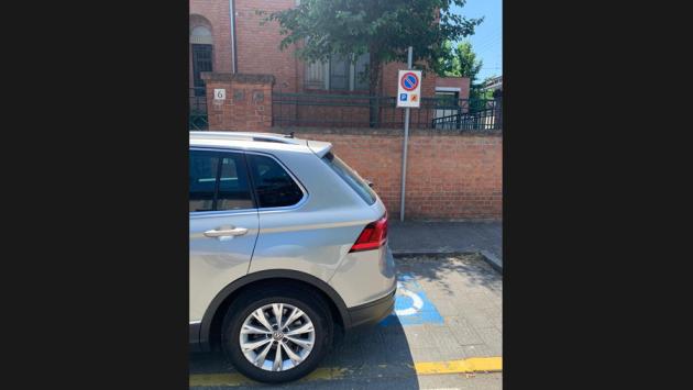 Va a recuperare il figlio a scuola. E gli insegna che si può parcheggiare così...
