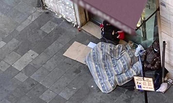 Senzatetto dorme davanti a negozio