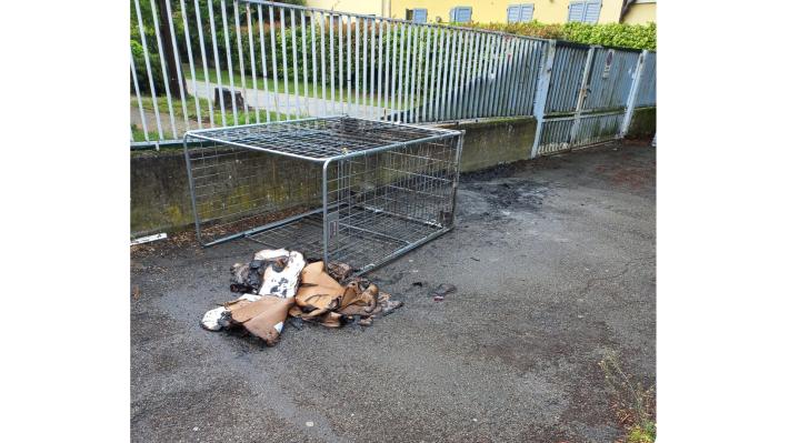 Davanti alla scuola materna Tartaruga, in via Newton, un carrello e alcuni cartoni andati a fuoco