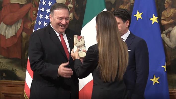 Una 'Iena' irrompe all'arrivo di Pompeo a Palazzo Chigi e gli consegna del Parmigiano