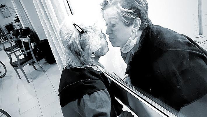 Amore batte  Covid: bacio attaverso il plexiglass